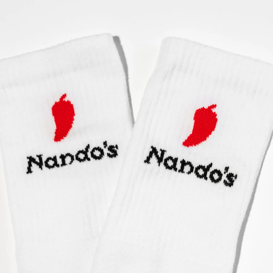 White socks embroidered with mini chillies and the Nando’s logo.